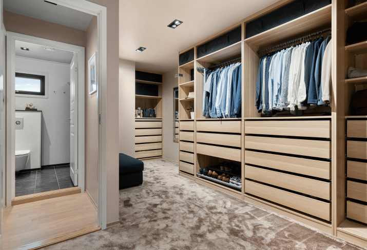 Vestidor a medida con estanterías de madera clara y iluminación empotrada
